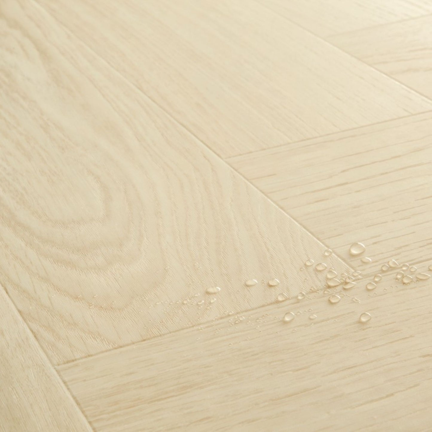 Pavimento in PVC CIRO ROVERE POLARE PURO QUICK-STEP con motivo a spina di pesce, posa Unizip e materassino integrato