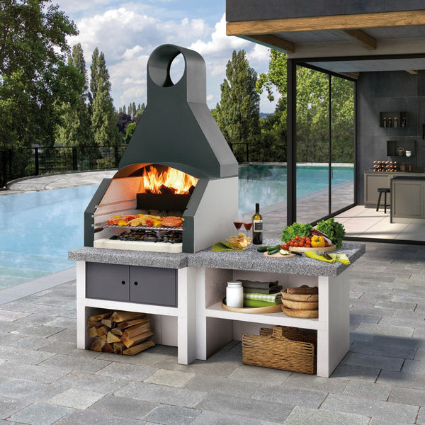 Barbecue a legna in cemento MAXIME CAPPA INOX per giardino - PALAZZETTI con piano Marmotech, vano con antine e doppio caricamento legna