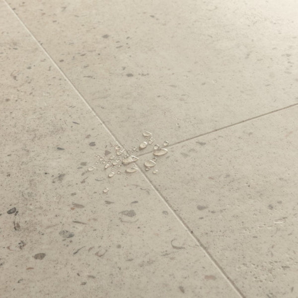 Pavimento in PVC ILLUME CEMENTO OSTRICA QUICK-STEP pietra con tonalità grigio chiaro consente di valorizzare ambienti luminosi e ordinati