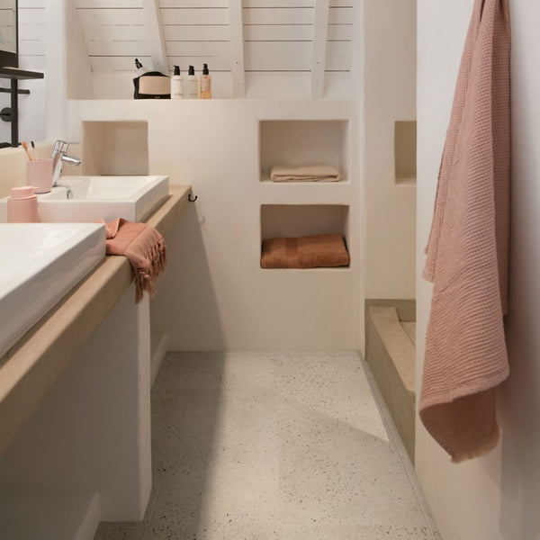 Pavimento in PVC ILLUME CEMENTO OSTRICA QUICK-STEP pietra con tonalità grigio chiaro consente di valorizzare ambienti luminosi e ordinati