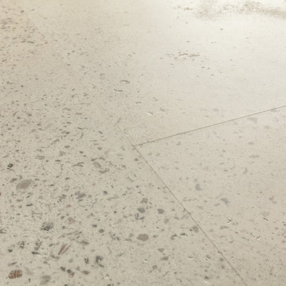 Pavimento in PVC ILLUME CEMENTO OSTRICA QUICK-STEP pietra con tonalità grigio chiaro consente di valorizzare ambienti luminosi e ordinati