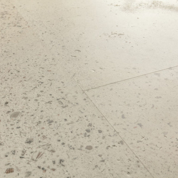 Pavimento in PVC ILLUME CEMENTO OSTRICA QUICK-STEP pietra con tonalità grigio chiaro consente di valorizzare ambienti luminosi e ordinati