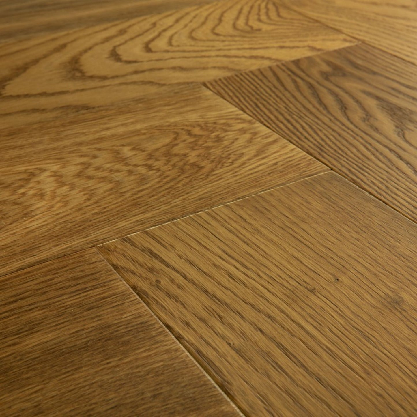 Pavimento in PARQUET DISEGNO ROVERE GREZZO CANNELLA EXTRA OPACO QUICK-STEP motivo a spina di pesce dona profondità e calore agli ambienti residenziali