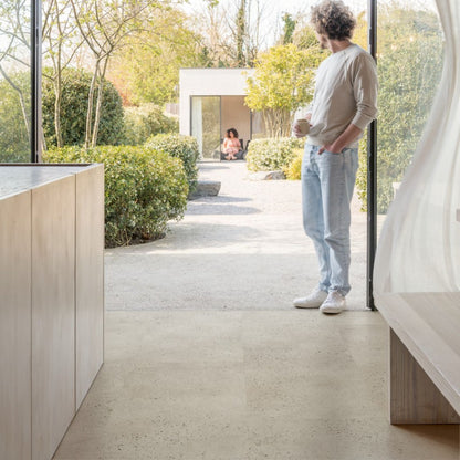 Pavimento in PVC ILLUME CEMENTO OSTRICA QUICK-STEP pietra con tonalità grigio chiaro consente di valorizzare ambienti luminosi e ordinati