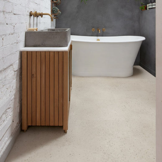 Pavimento in PVC ILLUME CEMENTO OSTRICA QUICK-STEP pietra con tonalità grigio chiaro consente di valorizzare ambienti luminosi e ordinati