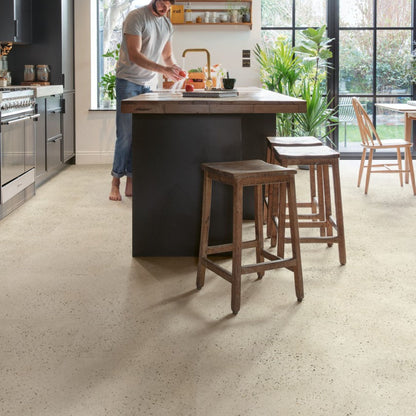 Pavimento in PVC ILLUME CEMENTO GHIAIA QUICK-STEP pietra con finitura cemento tonalità beige crea ambienti luminosi e continui