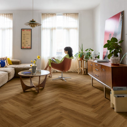 Pavimento in PVC CIRO ROVERE CARAMELLO BOTANICO QUICK-STEP motivo a spina di pesce restituisce un effetto legno profondo e strutturato