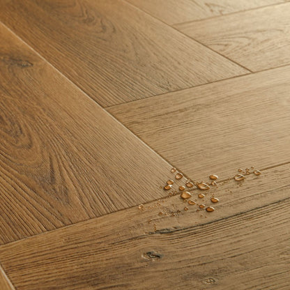 Pavimento in PVC CIRO ROVERE CARAMELLO BOTANICO QUICK-STEP motivo a spina di pesce restituisce un effetto legno profondo e strutturato