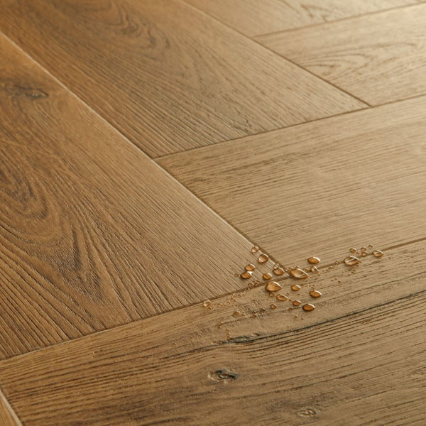Pavimento in PVC CIRO ROVERE CARAMELLO BOTANICO QUICK-STEP motivo a spina di pesce restituisce un effetto legno profondo e strutturato