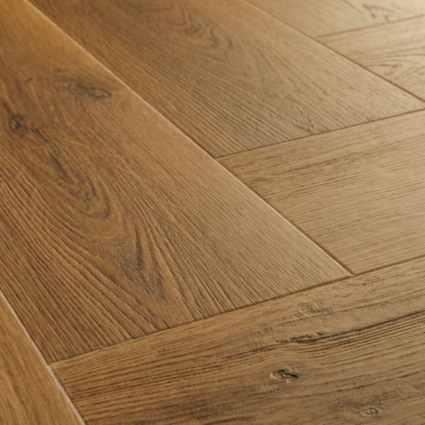 Pavimento in PVC CIRO ROVERE CARAMELLO BOTANICO QUICK-STEP motivo a spina di pesce restituisce un effetto legno profondo e strutturato