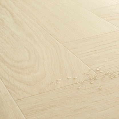 Pavimento in PVC CIRO ROVERE POLARE PURO QUICK-STEP con motivo a spina di pesce, posa Unizip e materassino integrato