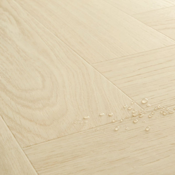 Pavimento in PVC CIRO ROVERE POLARE PURO QUICK-STEP con motivo a spina di pesce, posa Unizip e materassino integrato